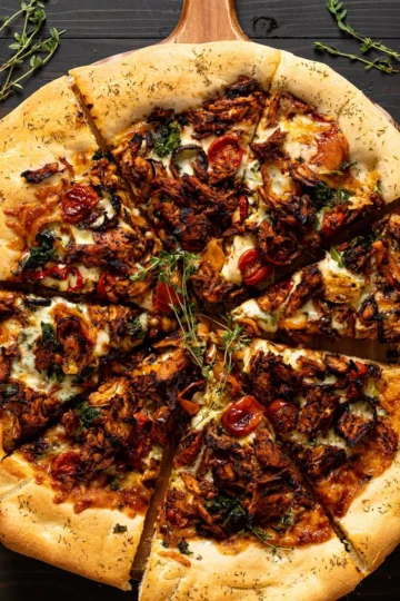 Delicious Jamaican jerk chicken pizza topped with fresh ingredients and spices.